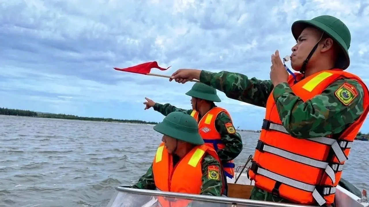 Cán bộ, chiến sỹ Đồn Biên phòng Lý Hòa (Bộ đội Biên phòng Quảng Bình) giúp ngư dân xã Đức Trạch, huyện Bố Trạch đưa thuyền lên bờ tránh trú. Ảnh: TTXVN