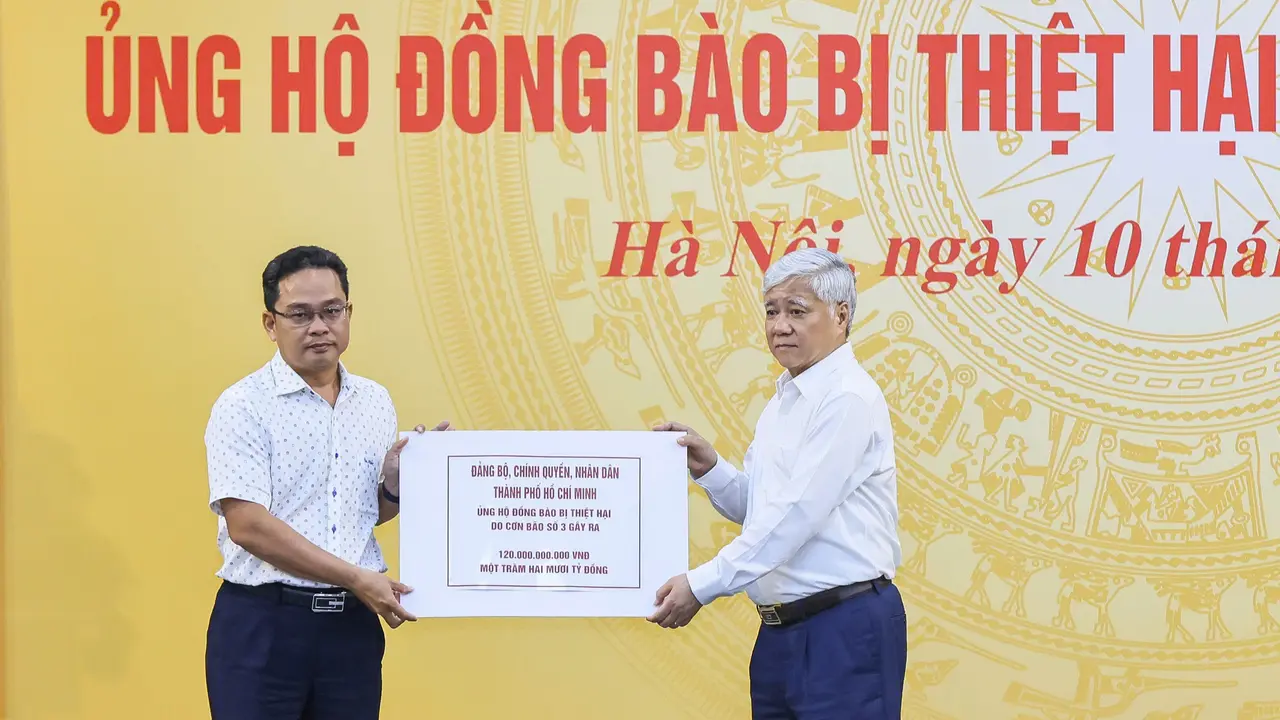 Ông Phạm Minh Tuấn, Phó Chủ tịch Ủy ban MTTQ Việt Nam TP.HCM trao bảng đăng ký ủng hộ cho Quỹ Cứu trợ Trung ương