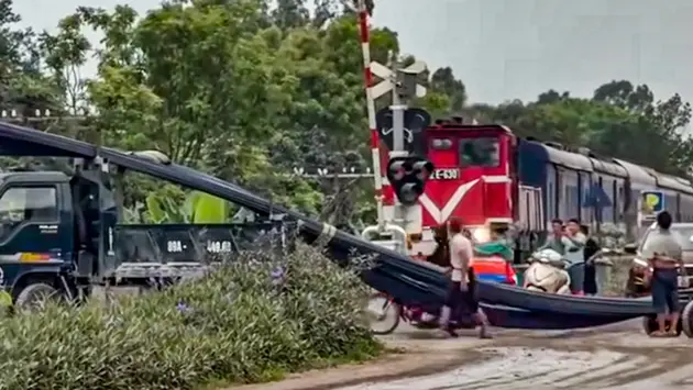 Tàu hỏa phanh gấp tránh xe tải chờ hàng cồng kềnh